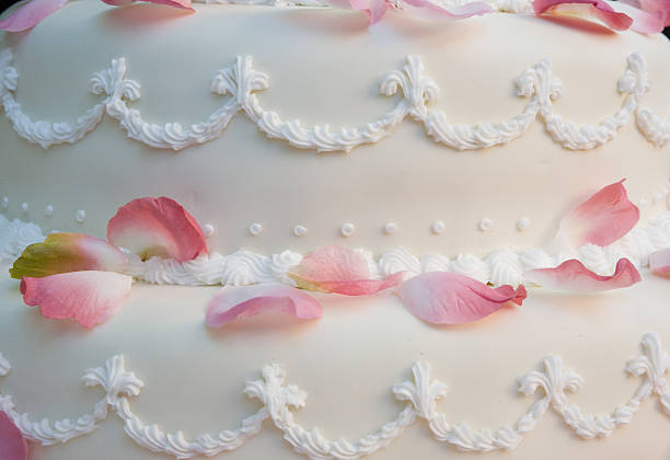 Close up detail of a wedding cake with rose pedals