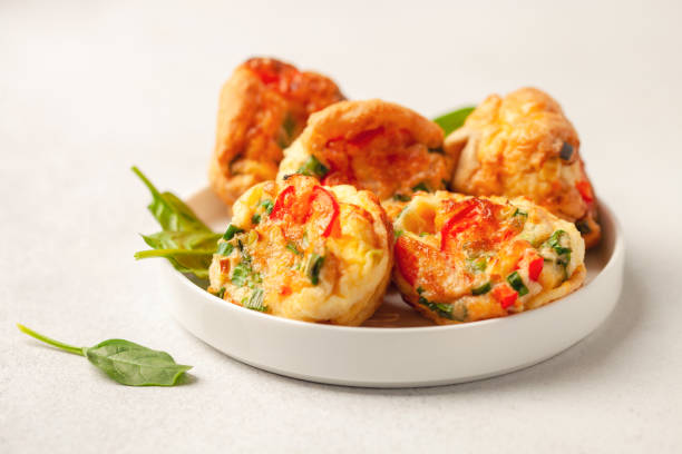 istock Egg muffins ( bites) and spinach leaves  in a plate on a gray background 1399928482