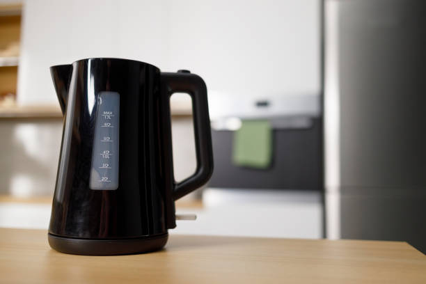 istock Modern electric kettle on wooden table in kitchen 1399934229