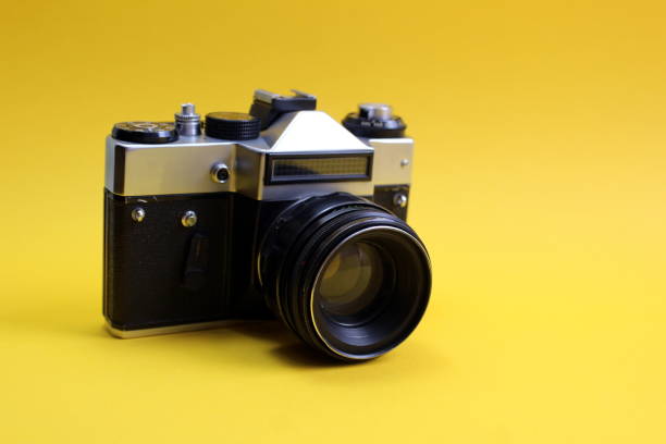 istock A retro black camera stands on a yellow background. 1399934269