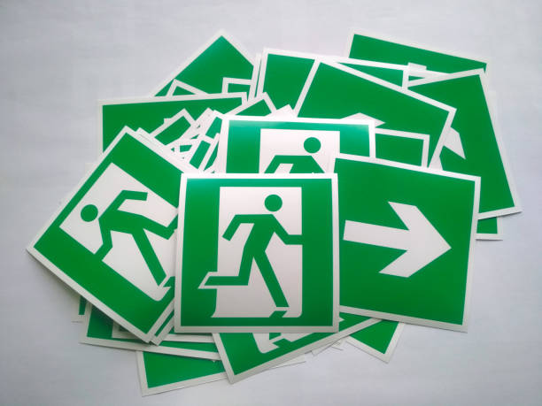 panneau de sortie d’incendie ou panneau d’évacuation d’incendie. pile d’autocollants fléchés d’évacuation. symbole blanc sur fond vert. avertissement de flèche d’urgence pour la sécurité à la sortie du bâtiment. - direction arrow sign road sign escape photos et images de collection