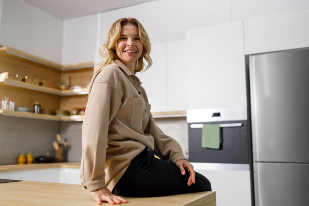 istock Joyful woman sitting on kitchen countertop 1399934709
