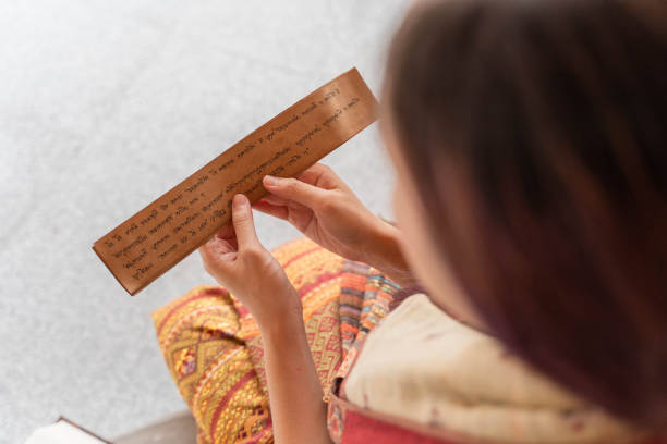 jeune femme asiatique lisant le sanskrit ancien livre tripitaka du seigneur bouddha dhamma - wat phra kaeo photos photos et images de collection