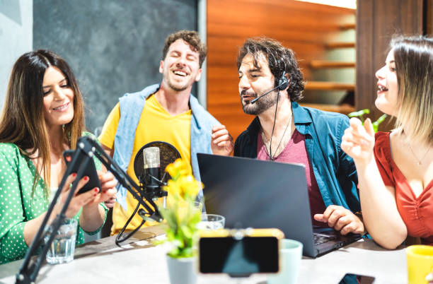 istock Young happy people sharing podcast on streaming platform with micro phone camera - Modern lifestyle concept with smart millenial men and women having fun vlogging live feeds on social media networks 1399938490