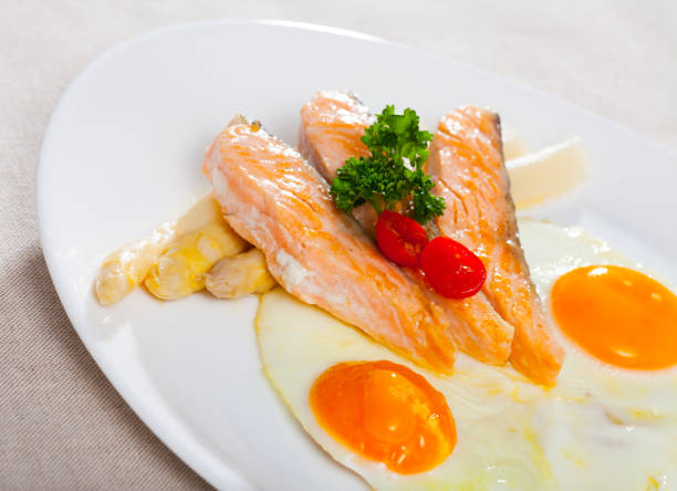 istock Delicious grilled salmon with eggs, tomatoes, asparagus and parsley 1399941151