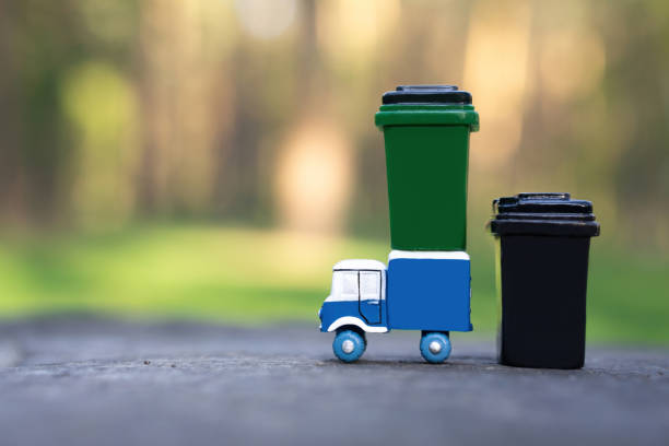 Colorful miniature recycling bins resting on a sandy beach highlight the significance of waste sorting and environmental responsibility for coastal ecosystem preservation
