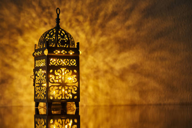istock Ornamental Arabic lantern with burning candle glowing at night. 1399943369