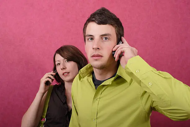 A woman and a man with telephones.