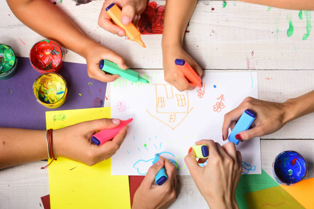 istock Artists wooden table with paints and colored paper 1399946155