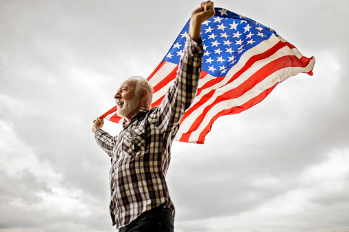 Older American Patriot holding the USA Flag