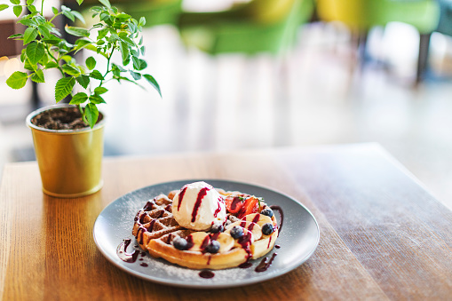 Belgian waffle with ice cream, chocolate and berries