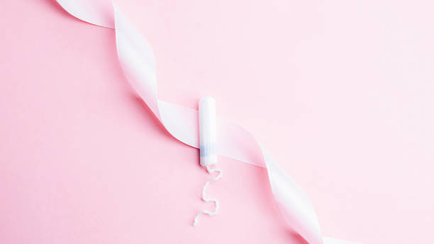 menstrual tampon feminine hygiene. pink ribbon with menstrual tampon on pink background. menstruation feminine period. sanitary hygiene concept. medical healthcare gynecological banner. - menstruation tampon gynecological examination sex imagens e fotografias de stock