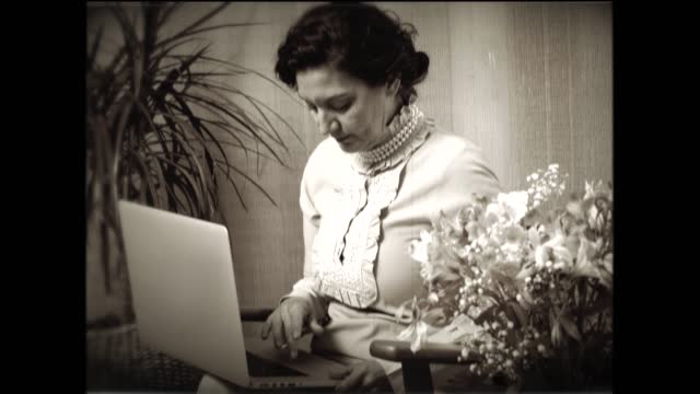 Vintage 1920s movie of a woman using a laptop.