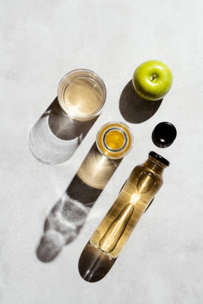 Apple juice and apples, directly above, table top shot. Fresh fruit juice in glass bottle and drinking glass.