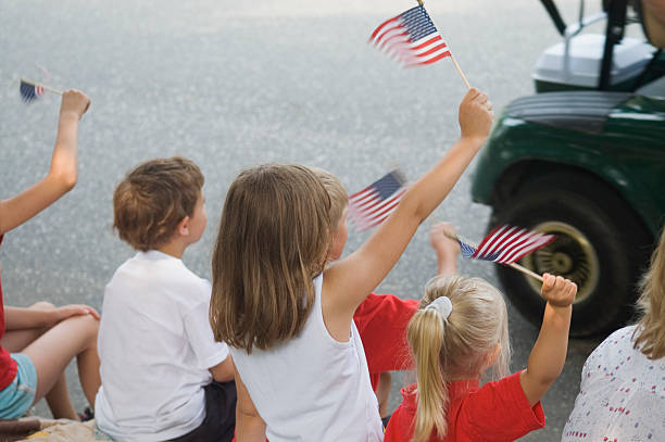 4th ofJuly Kids waving flags at a parade parade stock pictures, royalty-free photos & images
