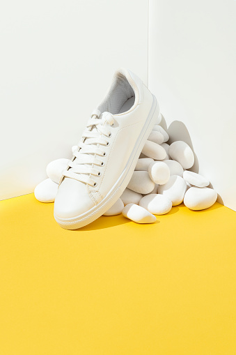 White sneaker with white stones on white and yellow background