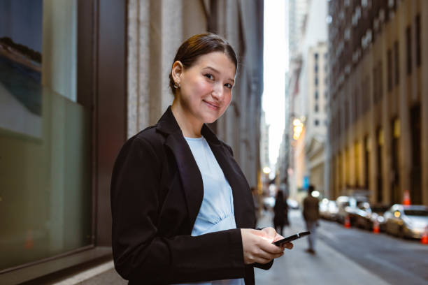 istock Hispanic businesswoman using mobile phone in front of the office 1399954249
