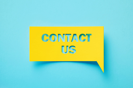 Contact us written rectangular shaped yellow chat bubble sitting on turquoise background. Horizontal composition with copy space.