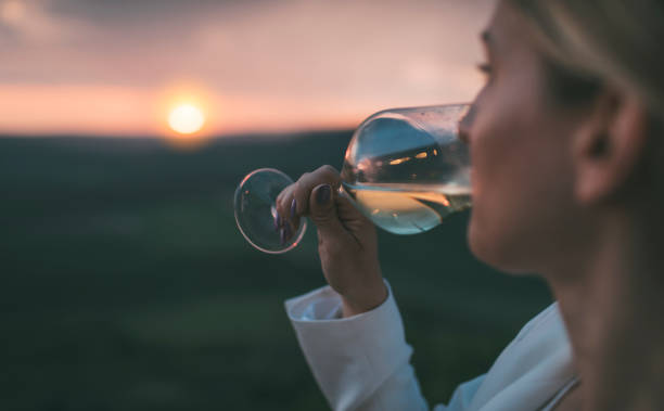 Woman drinking white wine stock photo