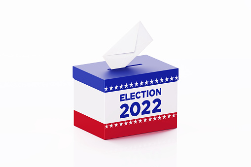 Election 2022 written ballot box textured with American flag. Isolated on white background. A vote envelope is entering into the ballot box. Horizontal composition with copy space. Great use for referendum and presidential elections related concepts. Clipping path is included.