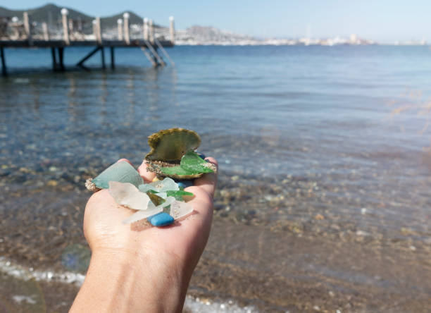 Mediterranean sea beach and glass stones photo. Glass stones from broken bottles polished by the sea. Front view photography with blurred background. High quality picture for wallpaper, travel blog