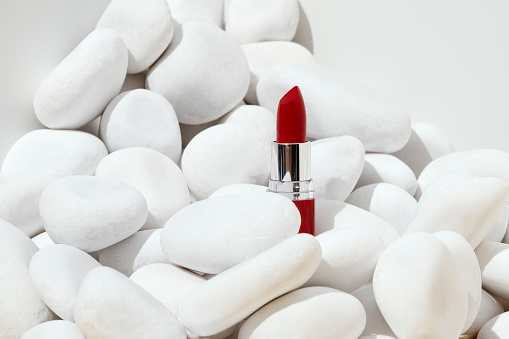 Red lipstick with white stones on white background