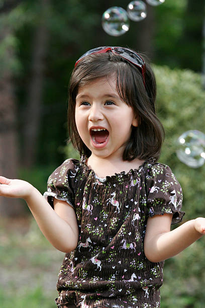 istock girl laughing and chasing bubbles 139995845