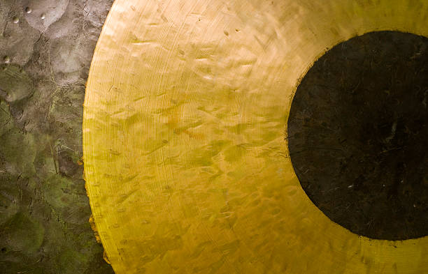 Hand hit big gong in temple.