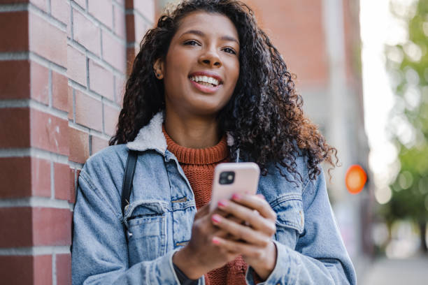 istock Young woman using smart phone in downtown area 1399959301