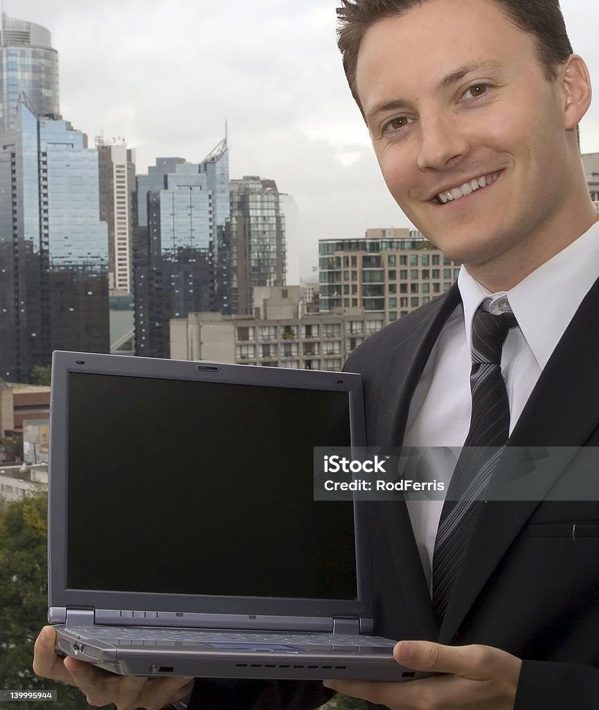 Visit our website A businessman is showing off a laptop with a blank screen. Agreement Stock Photo