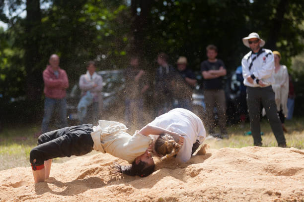 Pleyber-Christ, France - May 29 2022: Two young women practicing Breton wrestling (gouren) taking place on sawdust.
