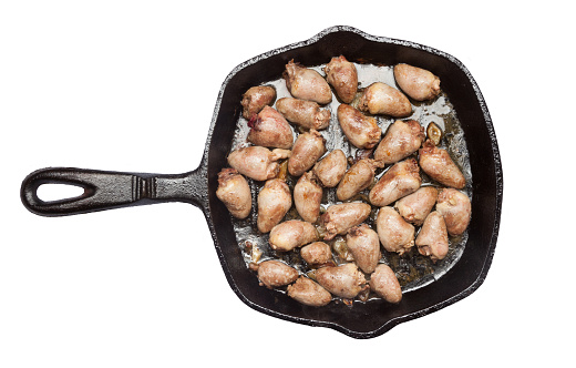 chicken heart saute in an iron pan, isolate on white