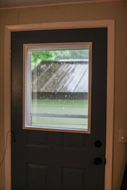 Spring Rain And Stormy Weather Spring Rain Falling outside an apartment window on a second story level. looking out front door stock pictures, royalty-free photos & images