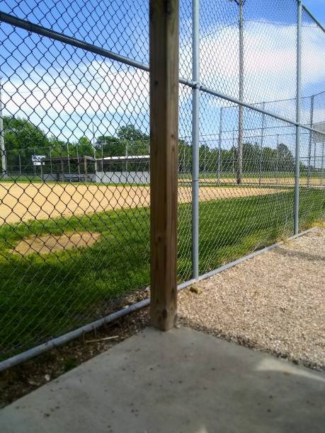 istock Empty youth baseball field view through chain link fence 1399969206
