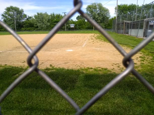 istock Empty baseball field view of home plate through a chain link fence 1399969211