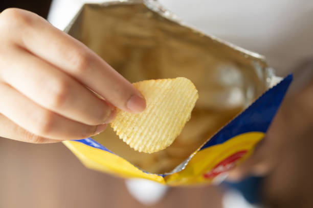 istock Hand hold potato chips with snack bag 1399980877
