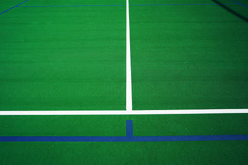 A Tennis Court has been marked off with blue tape for pickleball.