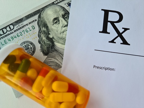 Dollar bill and doctor prescription with pills lie on doctor table in clinic closeup