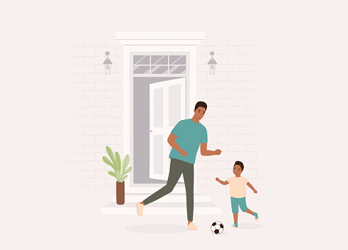 Happy Black Father With His Son In Preschool Age Playing Soccer Ball Outside Their Home. Isolated On Color Background.