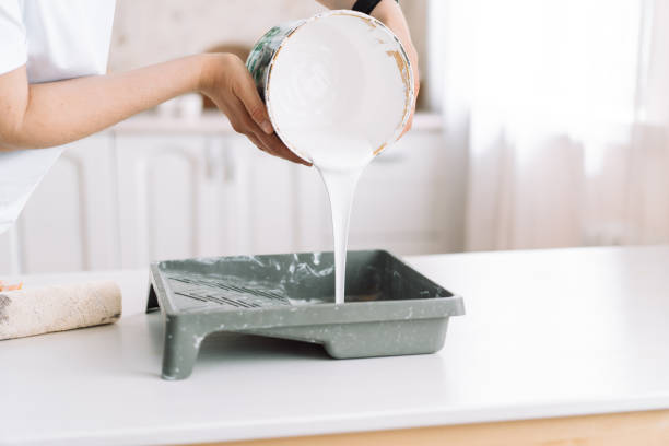 istock Girl pours white paint from can into ditch 1399991937