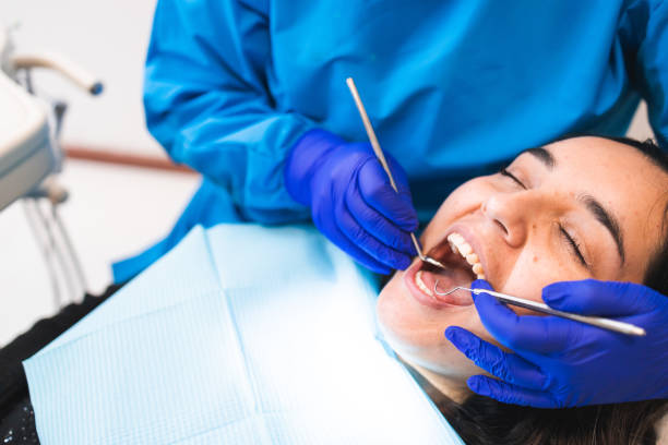 unkenntlicher zahnarzt, der eine routinemäßige zahnärztliche untersuchung mit einem mundspiegel und einem bagger an einer patientin durchführt - laboratory dentures dental hygiene human teeth stock-fotos und bilder