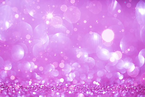Xmas glowing flare winter colors background.Glitter Christmas wallpaper.Pink purple blue shiny holiday backdrop.