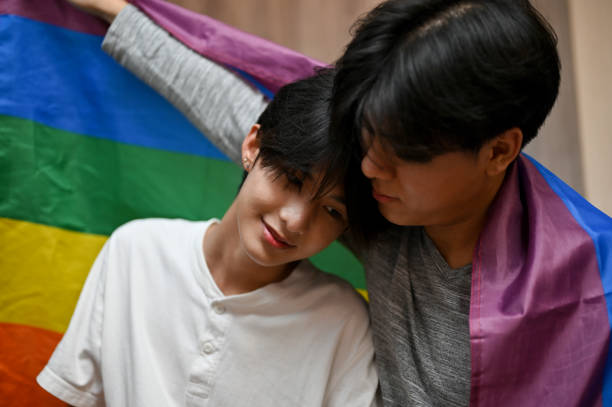 Romantic asian teenage gay men couple, a man put his head on his boyfriend shoulder Romantic asian teenage gay men couple, a man put his head on his boyfriend shoulder, sharing some romantic affection. LGBT rainbow flag trans boy stock pictures, royalty-free photos & images