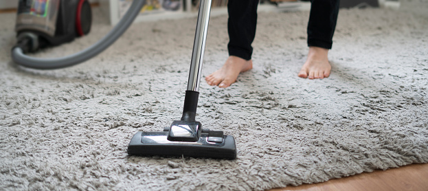 doing clean up at home, using vacuum cleaner to wash the floor