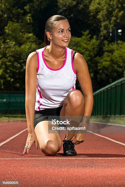 Młoda Kobieta W Sprint Pozycji - zdjęcia stockowe i więcej obrazów Bieg kobiet - Bieg kobiet, Biegać, Dorosły