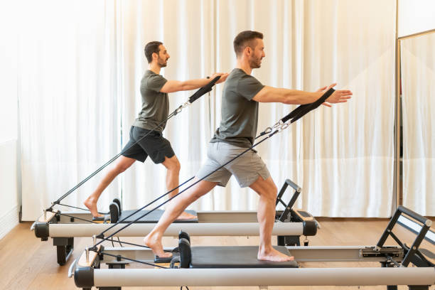 istock Fit men exercising on pilates machines in gym 1400007632