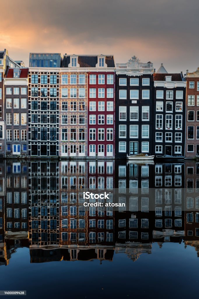 Amsterdam City Scene,  typical dutch houses and their reflection in the canal. Amsterdam City Scene,  typical dutch houses and their reflection in the canal. Old 17th and 18th century brick houses along a canal in centre of Amsterdam, Netherlands. Amsterdam Stock Photo