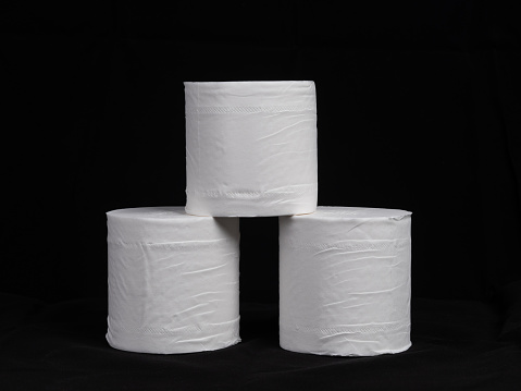 Pile of toilet paper rolls on black background