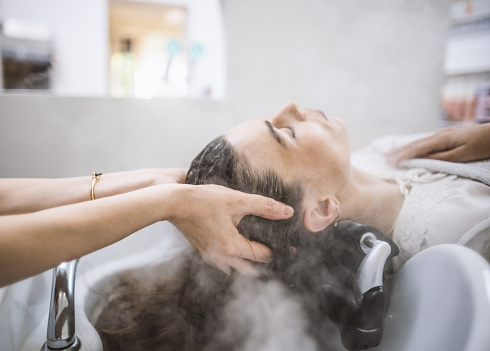 Photo of hairdresser doing hair spa treatment in hair salon