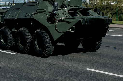 Wheels of military armored personnel carrier on asphalt